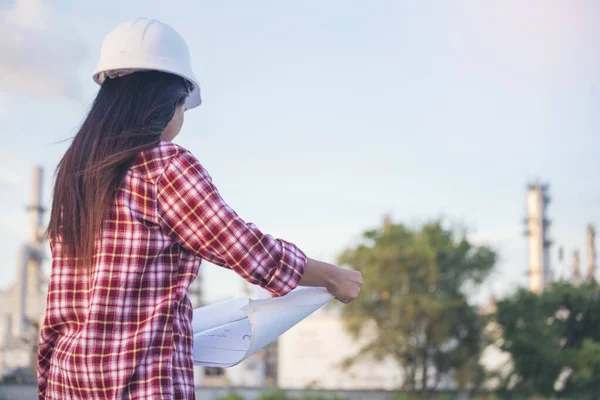 Woman worker hands holding hardhat yellow work helmet Construction Engineer. Refinery woman worker oil petro industry hand hold yellow worker helmet hard hat. Refinery industry engineer manufacture