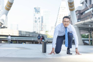 Asyalı adam kameraya bak, gülümse, gözlük tak. Erkek mutluluğu bir iş hedefi oluşturur. İş adamı ırkı konsepti. İş adamı diz çökmeye başlasın. Sokak yarışı kazananı düellosu.
