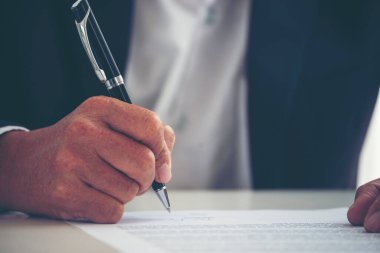 İş adamı, konferans odasında projelere başlamak için kalem imzası kullanıyor. İşletme müdürü toplantı odasında kontrat imzaladı. İş anlaşması kavramı