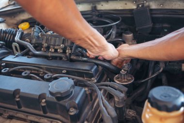 Otomobil makinelerinin mekanik servisini tamir eden elleri kapatın. Tamirci araba tamirhanesini tamir ederken ellerini kaldırdı. Araç kaputu otomobili kontrol ediyor. Araç bakım mühendisi.