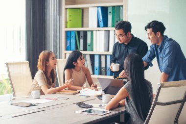 Bir grup iş adamı konferans odasında toplantı yapıyor. İşletme doküman grafiği ofis masasına danışmak için beyin fırtınası yapıyorlar. Çeşitli etnik gruplardan iş adamları beyin fırtınası yapıyor ve birlikte çalışıyorlar..