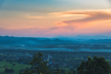 Mavi altın gökyüzü gün doğumu dramatik manzara dağları. Şafak vakti altın rengi alacakaranlık zamanı güneş ışığıyla bulutlu manzara. Dağ manzarasında dramatik bir gün batımı. Güzel manzara sisli tepeler alacakaranlık vakti
