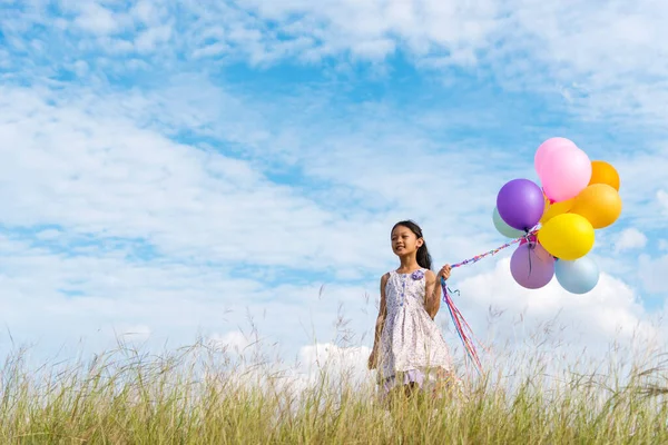 Vrolijk Schattig Meisje Houden Ballonnen Lopen Groene Weide Witte Wolk — Stockfoto