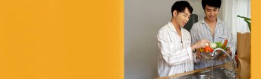 Banner Asian two Man hands wash cleaning fresh vegetable in kitchen. Panorama Happy Asian LGBTQIA gay couple homosexual cooking together in kitchen. Men wash vegetable salad home cook with copy space