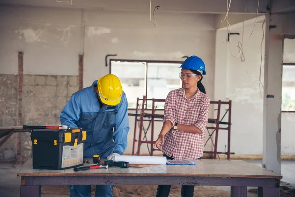 Construction engineer teamwork Safety Suit Trust Team Holding White Yellow Safety hard hat Security Equipment on Construction Site. Hardhat Protect Head for Civil Construction Engineer Concept