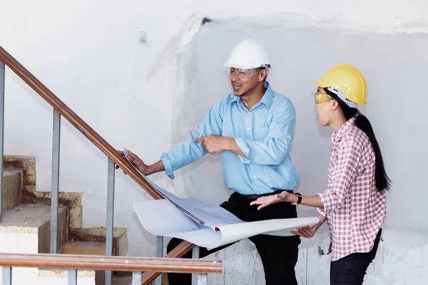 Construction engineer teamwork Safety Suit Trust Team Holding White Yellow Safety hard hat Security Equipment on Construction Site. Hardhat Protect Head for Civil Construction Engineer Concept