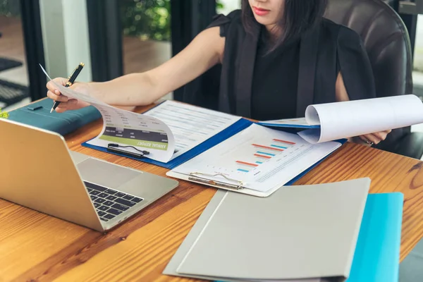 Akıllı telefon kullanan bir iş kadını, ofis masasında dizüstü bilgisayar. Finansal grafik grafikleri okuyan serbest çalışan bir kadın pazarlama verilerini analiz etmeyi planlıyor. Şirkette çalışan genç bir kadının elleri..