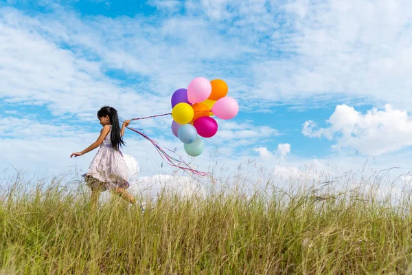 Vrolijk Schattig Meisje Houden Ballonnen Lopen Groene Weide Witte Wolk — Stockfoto