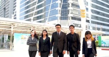 Group of business people asian team partners walking in city happy together. Leader executive men standing at modern urban city with confident teamwork. Portrait diversity businesspeople teamwork