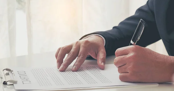 Businessman hand using pen signing on new contract to starting projects in conference room. Close up business manager man hands sign contract legal document in meeting room. Business agreement concept