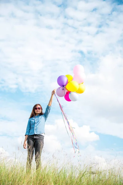 Kobieta Trzyma Balony Działa Zielonej Łące Białą Chmurę Błękitne Niebo — Zdjęcie stockowe