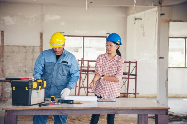 Construction engineer teamwork Safety Suit Trust Team Holding White Yellow Safety hard hat Security Equipment on Construction Site. Hardhat Protect Head for Civil Construction Engineer Concept