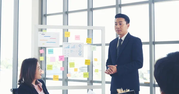 Happy business people meeting present graph chart investment, business data in meeting room. Group of business people meeting in conference room. Asian businessman speech, present teamwork partnership