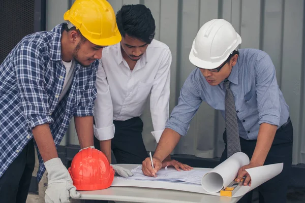 Civil engineer teams meeting working together wear worker helmets hardhat on construction site in modern city. Foreman industry project manager engineer teamwork. Asian industry professional team