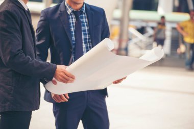 İnşaat mühendisi takımları modern kentteki inşaat sahasında birlikte çalışan işçi kaskı takıyorlar. Foreman Endüstri Mühendislik Mühendisliği ekip çalışması. Asya endüstrisi profesyonel takımı