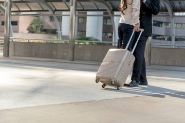 İş adamları iş gezisinde bavulla yürüyen çift aşığı. Balayı iş gezisinde yolcu terminalinde kucaklaşırız. Havaalanı yolcusu çiftin bavullarıyla iş seyahati.