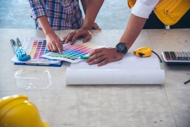 İnşaat mühendisi takımları modern kentteki inşaat sahasında birlikte çalışan işçi kaskı takıyorlar. Foreman Endüstri Mühendislik Mühendisliği ekip çalışması. Asya endüstrisi profesyonel takımı