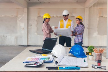 İnşaat mühendisi takımları modern kentteki inşaat sahasında birlikte çalışan işçi kaskı takıyorlar. Foreman Endüstri Mühendislik Mühendisliği ekip çalışması. Asya endüstrisi profesyonel takımı