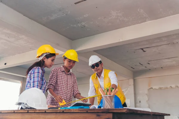 Civil engineer teams meeting working together wear worker helmets hardhat on construction site in modern city. Foreman industry project manager engineer teamwork. Asian industry professional team