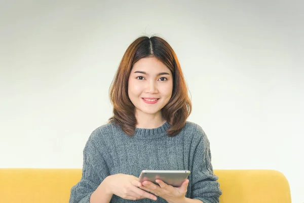 Asian woman using digital tablet shopping online, call, texting message internet technology lifestyle with smiling face. Asian woman touch smart tablet focus on hands using mobile app home office.