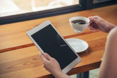 İnternetten dijital tablet alışverişi yapan Asyalı bir kadın arıyor, mesaj yolluyor, internet teknolojisi yaşam tarzında gülümsüyor. Asyalı kadın akıllı tablete dokunuyor mobil uygulama ev ofisini kullanarak ellere odaklanıyor.