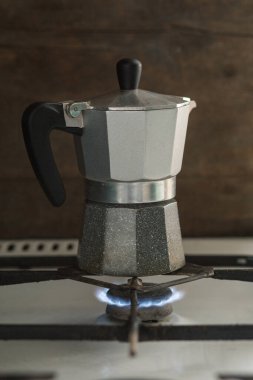 Turk coffee maker stands on a gas stove. Visible fire
