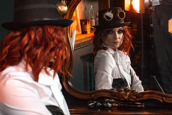 Beyaz gömlekli, deri şapkalı, yuvarlak gözlüklü aynadaki yansıma.