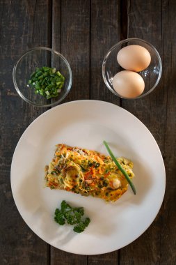 Balık, yumurta, soğan ve havuçtan yapılmış bir parça turta. Beyaz tabaklar, tahta tahtalar.