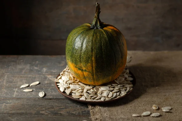 Pompoen Een Bord Met Pompoenpitten Een Houten Tafel — Stockfoto