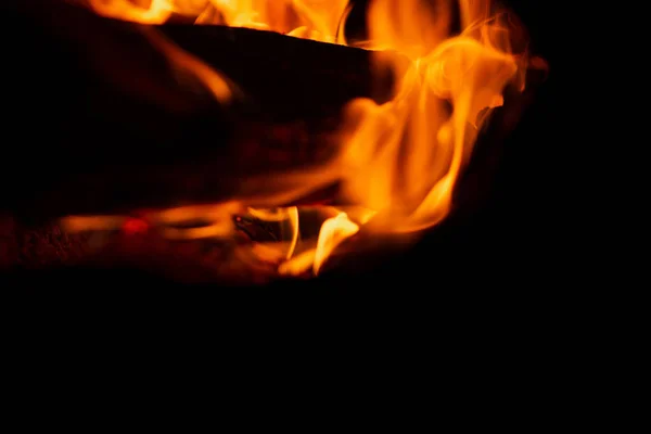 Burning firewood in the fireplace in the oven. Fire texture on black background