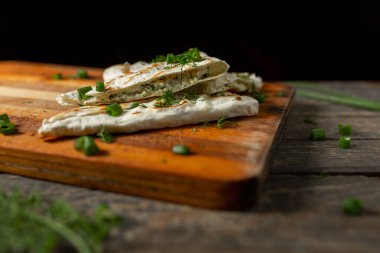 Bir tabak süzme peynir maydanozlu ve ızgarada kızartılmış pita ekmeğinde soğan.