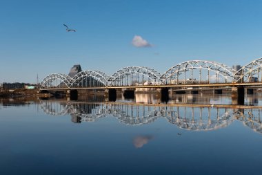 Riga, Letonya 'daki Daugava Nehri üzerindeki demiryolu köprüsü baharda güneşli bir gün.
