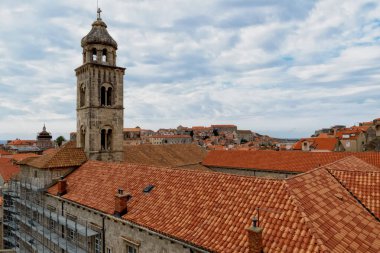 Hırvatistan 'ın eski Dubrovnik kentinde bulutlu mavi gökyüzüne karşı kilise kulesi ve çatı.
