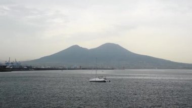 Akdeniz kıyısındaki Napoli Körfezi 'nde Vezüv Dağı' nın arka planında yelkenli.