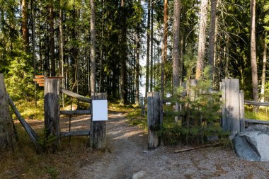 Ormandaki eski bir ahşap çitin kapısında boş beyaz tabela