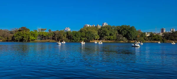 lake in park on a sunny weekend with paddle boat ride in the countryside of brazil