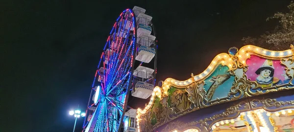 遊園地の観覧車とカルーセル — ストック写真