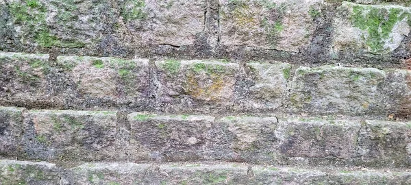 old brick wall of dark stones, which can be used as a background