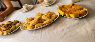 Ekmek ve hamur işleriyle kahvaltı, süt beyazı havluyla