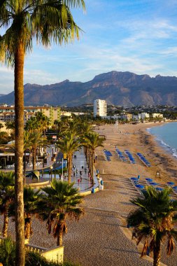 Gün doğarken, bir grup insan Altea İspanya sahilinde yoga yapıyor.