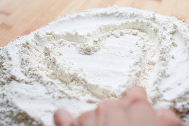 Kadın un ile kalp işareti yapıyor.