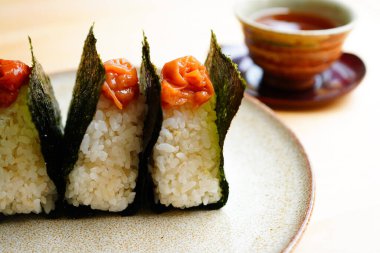 Onigiri 'nin yakın çekimi Nori' de, Umeboshi üstte.