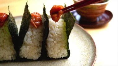 Onigiri 'ye Umeboshi süren kadın (pirinç topu)