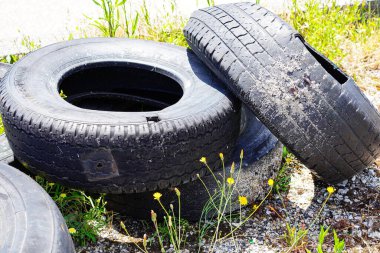 Kullanılmış lastikler bir tarlaya atılmış.