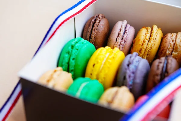 Assorted macaroons in cake boxe decorated with ribbon of French flag colors