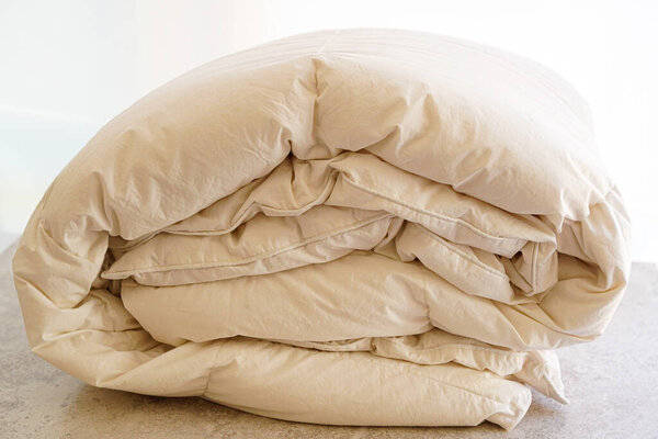 Folded duvet in room with soft light filter 