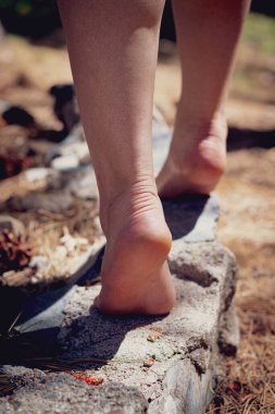 Taş bir duvar boyunca dengede duran ayaklar