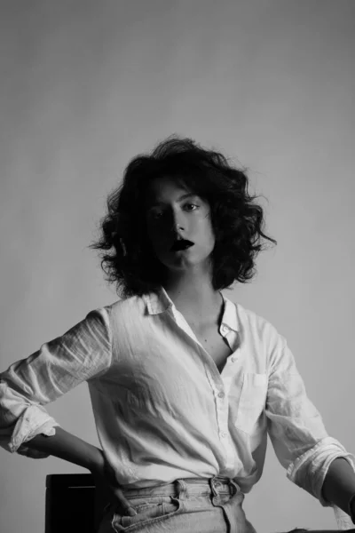 스튜디오에서 포즈를 취하고 있는 젊은 여성의 수직 사진. 흑백. — 스톡 사진