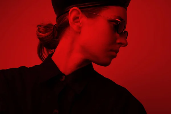 Kırmızı ışıklı genç bir kadının portresi, güneş gözlüğü takıyor.. — Stok fotoğraf