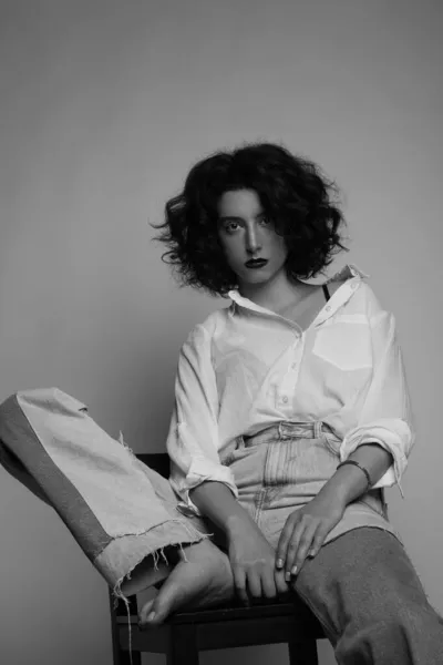 Fekete-fehér portré fiatal nő, göndör haj pózol a stúdióban. — Stock Fotó